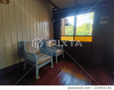 Cozy balcony interior wicker chair wooden floor window sunlight rustic peaceful morning light 135003136