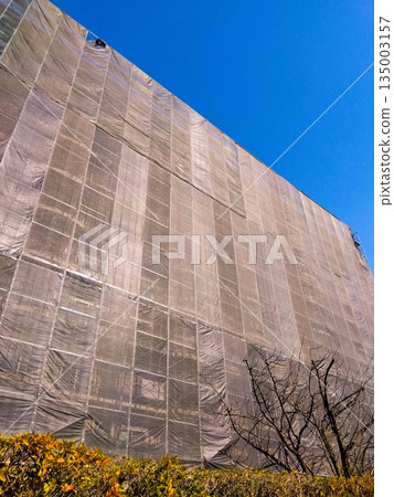 Apartment complex undergoing large-scale repair and painting work and the blue winter sky Apartment complex undergoing large-scale repair and painting work and the blue winter sky 135003157