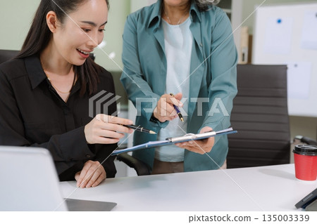 Businessmen team or financial data analysts working with tablets and laptop computers and data graphs together. Plan to analyzing projects in the office. 135003339