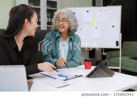 Asian businessman discuss with new startup project Idea presentation, analyze planning and financial statistics and investment market at office. Asian businessman discuss with new startup project Idea presentation, analyze planning and financial statistics and investment market at office. 135003341