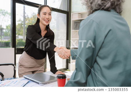 Business team analyzing documents, graphs, and data with a laptop, tablet, and smartphone. Collaboration, strategy, and success. Business team analyzing documents, graphs, and data with a laptop, tablet, and smartphone. Collaboration, strategy, and success. 135003355