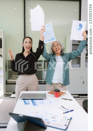 Business team analyzing documents, graphs, and data with a laptop, tablet, and smartphone. Collaboration, strategy, and success. Business team analyzing documents, graphs, and data with a laptop, tablet, and smartphone. Collaboration, strategy, and success. 135003359