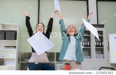 Business team analyzing documents, graphs, and data with a laptop, tablet, and smartphone. Collaboration, strategy, and success. Business team analyzing documents, graphs, and data with a laptop, tablet, and smartphone. Collaboration, strategy, and success. 135003361