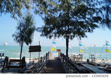 A beautiful wooden bridge on rocks leading to the sea.A pier leading to the sea 135003836