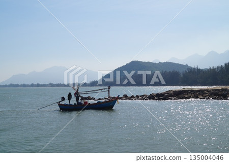 Wooden fisherman's boat at sea.A small, wooden, colorful fisherman's boat returning from fishing to the village. 135004046