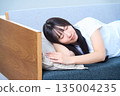 A young Japanese woman taking a comfortable nap in the fa 135004235