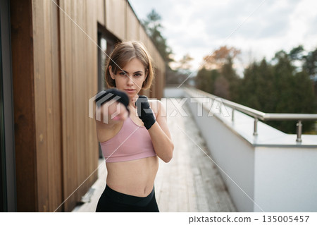 Woman preparing for fitness training with boxing wraps. Woman preparing for fitness training with boxing wraps. 135005457