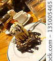 Enjoy a coffee break with chocolate cake topped with ice cream 135005465