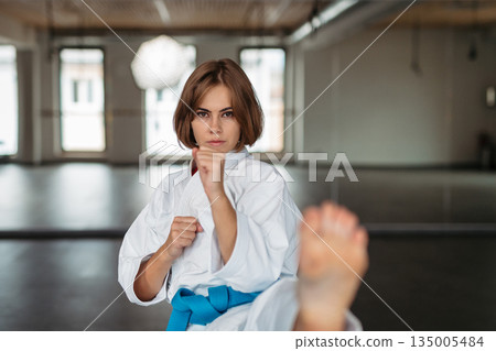 Portrait of focused woman training martial arts. Portrait of focused woman training martial arts. 135005484
