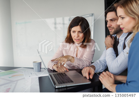 Group of coworkers discussing project strategy. Group of coworkers discussing project strategy. 135005497