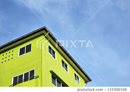 Bright Lime Green Building Corner Against Blue Sky. Bright Lime Green Building Corner Against Blue Sky. 135006506