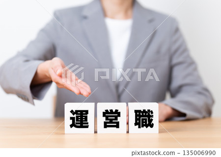 A middle-aged female businesswoman wearing a suit and a management job block A middle-aged female businesswoman wearing a suit and a management job block 135006990