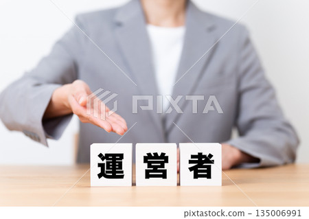 身穿職業套裝的中年女商務人士，手持操作塊 135006991