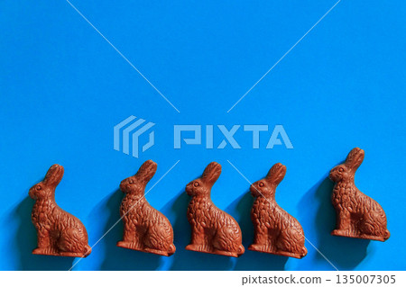Easter chocolate bunnies on blue background. Top view Easter chocolate bunnies on blue background. Top view 135007305