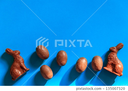 Easter chocolate bunnies and chocolate eggs on blue background. Top view 135007320