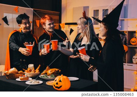 Friends enjoying a Halloween party at a bar making a toast Friends enjoying a Halloween party at a bar making a toast 135008463
