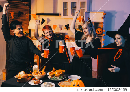 Friends enjoying a Halloween party at a bar making a toast Friends enjoying a Halloween party at a bar making a toast 135008469