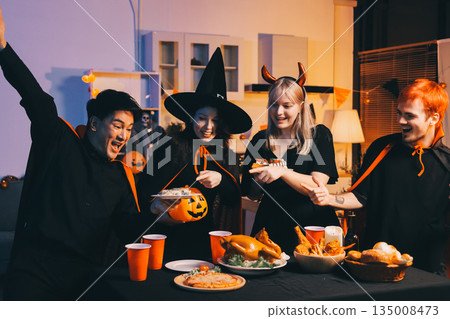 Friends enjoying a Halloween party at a bar making a toast Friends enjoying a Halloween party at a bar making a toast 135008473