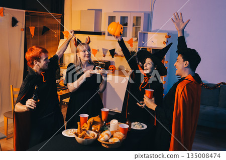 Friends enjoying a Halloween party at a bar making a toast 135008474