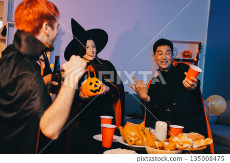 Friends enjoying a Halloween party at a bar making a toast 135008475