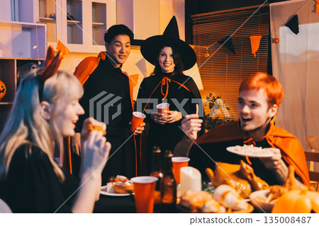 Friends enjoying a Halloween party at a bar making a toast 135008487