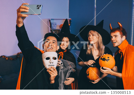 Friends enjoying a Halloween party at a bar making a toast 135008513