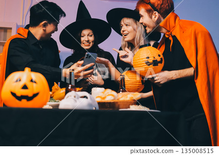 Friends enjoying a Halloween party at a bar making a toast 135008515
