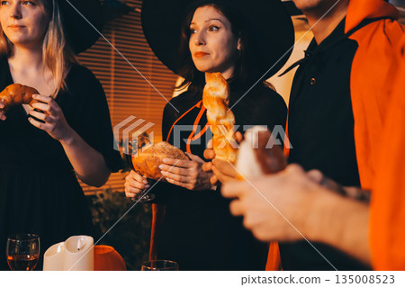 Friends enjoying a Halloween party at a bar making a toast Friends enjoying a Halloween party at a bar making a toast 135008523