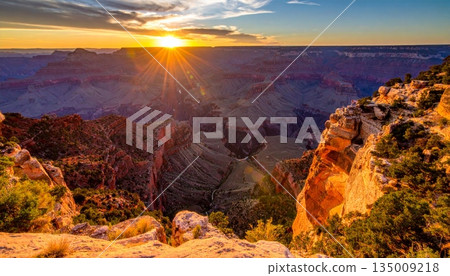 A scenic sunset and sunrise over the grand canyon in Arizona's national park reveal a majestic landscape of desert rocks, mountain clouds, and the vast scenic valley view 135009218