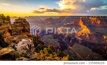 A scenic sunset and sunrise over the grand canyon in Arizona's national park reveal a majestic landscape of desert rocks, mountain clouds, and the vast scenic valley view 135009220