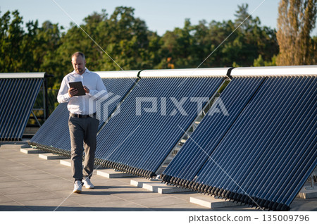 Engineer checking solar power system using digital tablet 135009796