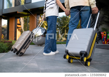 Couple with suitcases near luxury hotel entrance Couple with suitcases near luxury hotel entrance 135009842