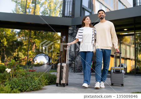 Couple with suitcases near luxury hotel entrance Couple with suitcases near luxury hotel entrance 135009846