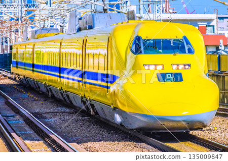 Yokohama cityscape, Japan. Doctor Yellow approaches Shin-Yokohama Station. Its beautiful form becomes clear as it enters a straight line. Yokohama cityscape, Japan. Doctor Yellow approaches Shin-Yokohama Station. Its beautiful form becomes clear as it enters a straight line. 135009847