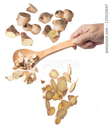 Galangal fall fly in turner, fresh vegetable spice galangal falling. Organic fresh herbal galangal root head cut chop slice, close up texture. White background isolated freeze motion high speed 135010047