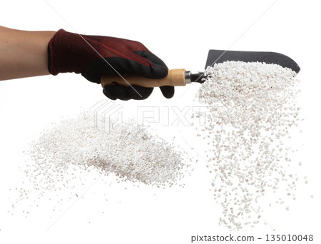 Perlite rock flying explosion, perlite white stone fall down from hand shovel garden. Perlite volcano stone splash throwing in Air. White background Isolated high speed shutter, freeze action 135010048