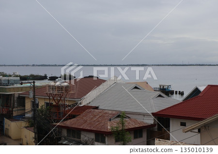 遠處城鎮的景色，天空陰雲密布，可以看到陸地、大海以及對岸的房屋。 135010139