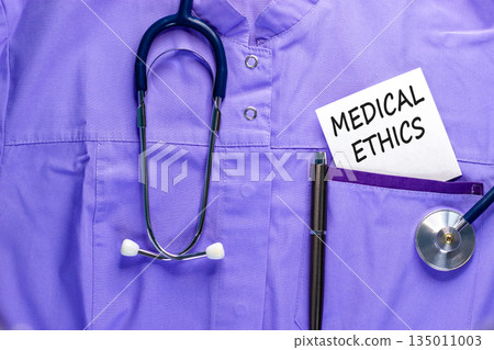 Medical ethics symbol. Concept words Medical ethics on beautiful white card. Stethoscope and pen. Beautiful medical uniform. Healthy lifestyle medical ethics concept. Medical ethics symbol. Concept words Medical ethics on beautiful white card. Stethoscope and pen. Beautiful medical uniform. Healthy lifestyle medical ethics concept. 135011003