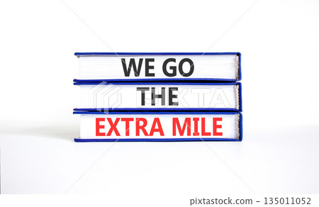 Support, help we go the extra mile symbol. Concept words We go the extra mile on beautiful books. Beautiful white paper background. Business we go the extra mile concept. Copy space. Support, help we go the extra mile symbol. Concept words We go the extra mile on beautiful books. Beautiful white paper background. Business we go the extra mile concept. Copy space. 135011052