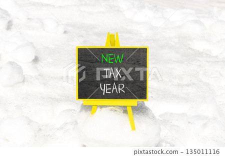 New tax year symbol. Concept words New tax year on beautiful black yellow blackboard. Beautiful white snow background. Business new tax year concept. Copy space. New tax year symbol. Concept words New tax year on beautiful black yellow blackboard. Beautiful white snow background. Business new tax year concept. Copy space. 135011116