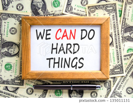 Support, help we can do hard things symbol. Concept words We can do hard things on beautiful wooden picture frame. Beautiful dollar bills background. Business we can do hard things concept. Copy space 135011131