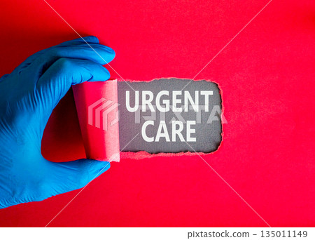 Urgent care symbol. Concept words Urgent care on beautiful grey paper. Doctor hand in blue medical glove. Beautiful red background. Medical healthy lifestyle urgent care concept. 135011149