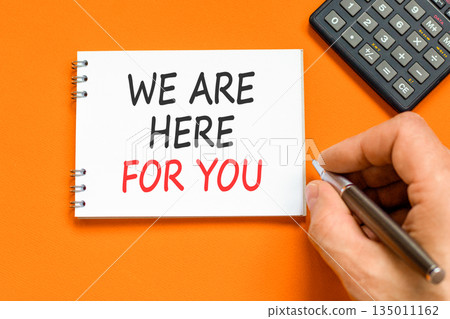 Support, help and we are here for you symbol. Concept words We are here for you on beautiful note. Beautiful orange background. Businessman's hand. Business we are here for you concept. Copy space. 135011162