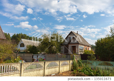 Landscape with a road passing through a deserted summer cottage village. 135011673