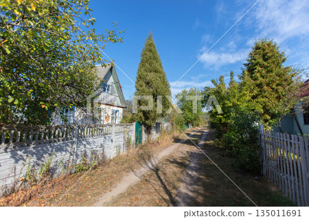 Landscape with a road passing through a deserted summer cottage village. 135011691