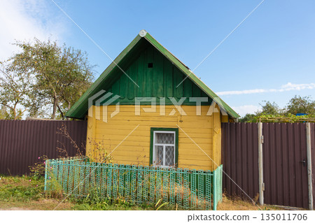 A small village one-story yellow house with one window. A small village one-story yellow house with one window. 135011706