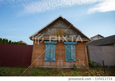 One-story Russian village house with carved shutters. One-story Russian village house with carved shutters. 135011714