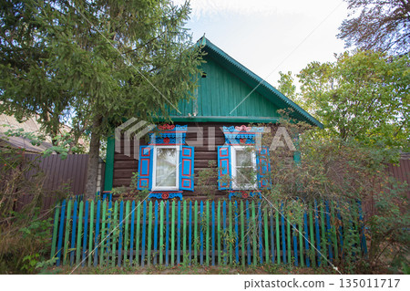 One-story Russian village house with carved shutters. 135011717