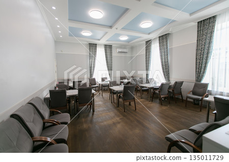 Interior of a meeting room with empty tables and chairs. Interior of a meeting room with empty tables and chairs. 135011729