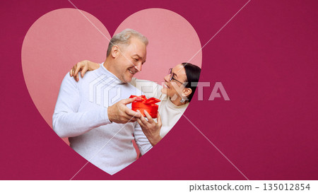 Lifestyle poster of mature couple with gift box inside heart. Lifestyle poster of mature couple with gift box inside heart. 135012854